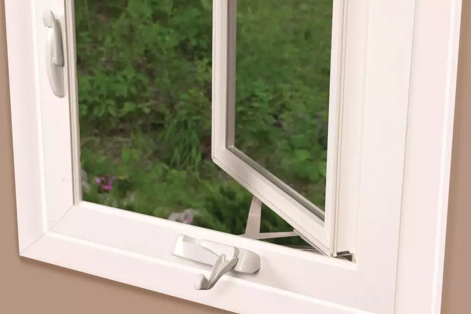 White casement window cranked open to a garden for ventilation.